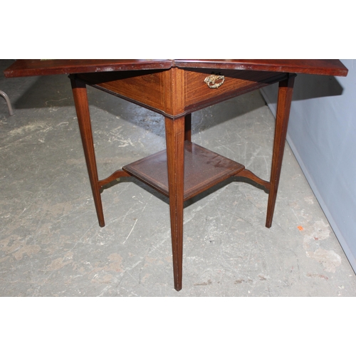 13 - A late 19th or early 20th century mahogany envelope card table with undertier, the top twists to ope... 