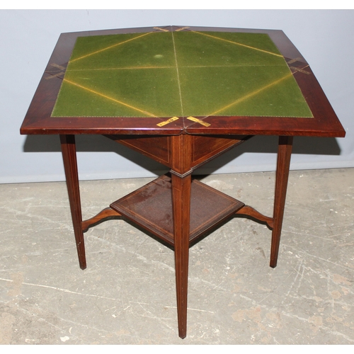 13 - A late 19th or early 20th century mahogany envelope card table with undertier, the top twists to ope... 