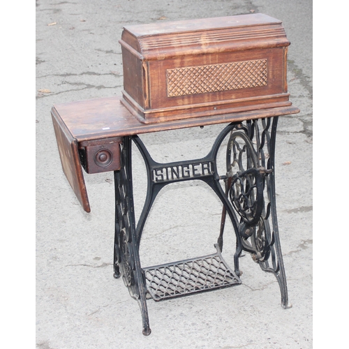 22 - An antique Singer sewing machine table with cast iron base, complete with machine