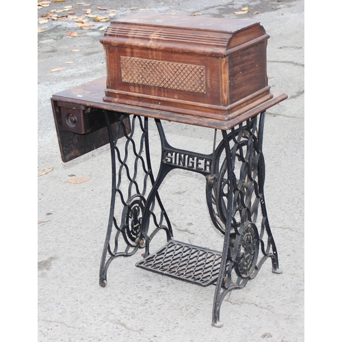 22 - An antique Singer sewing machine table with cast iron base, complete with machine