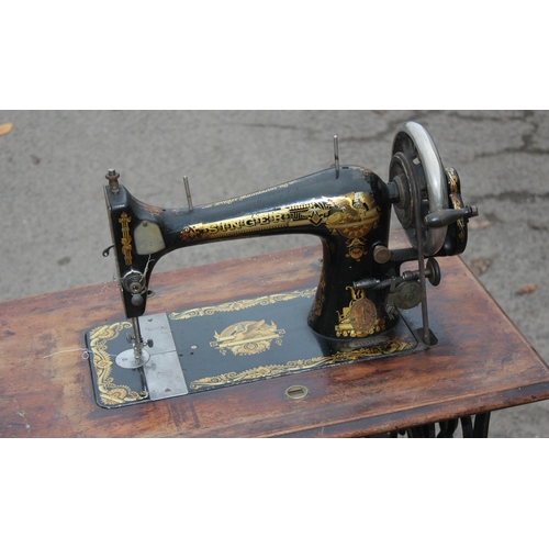 22 - An antique Singer sewing machine table with cast iron base, complete with machine