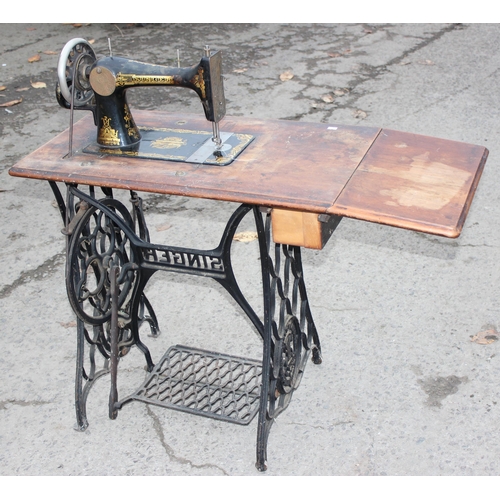 22 - An antique Singer sewing machine table with cast iron base, complete with machine