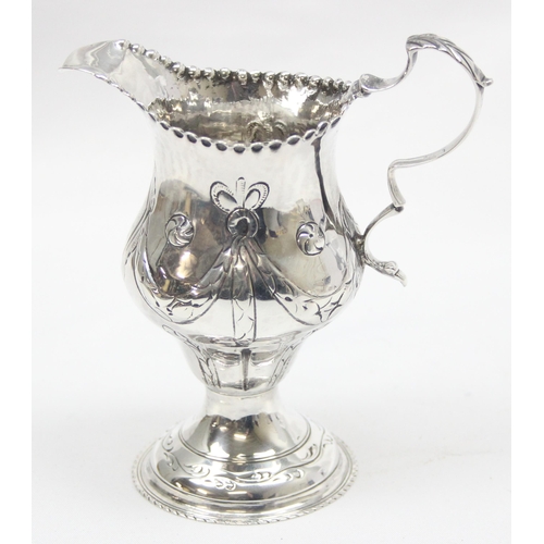 1002 - A George III period silver cream jug with embossed decoration, London 1774 by Thomas Shepherd, appro... 