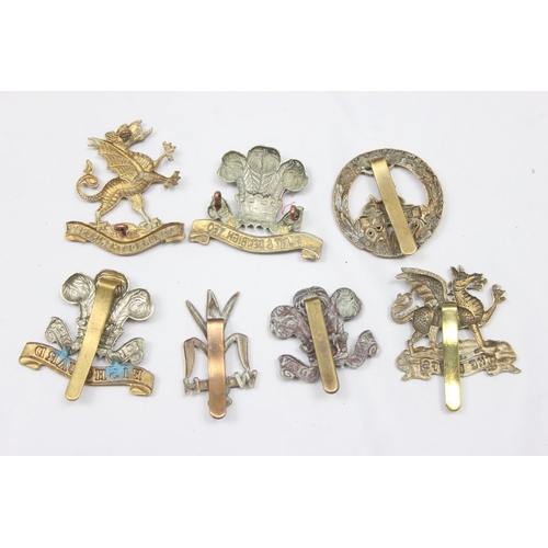 1411 - Military cap badges - 7 assorted military cap badges all relating to the Wales, to include The Buffs... 