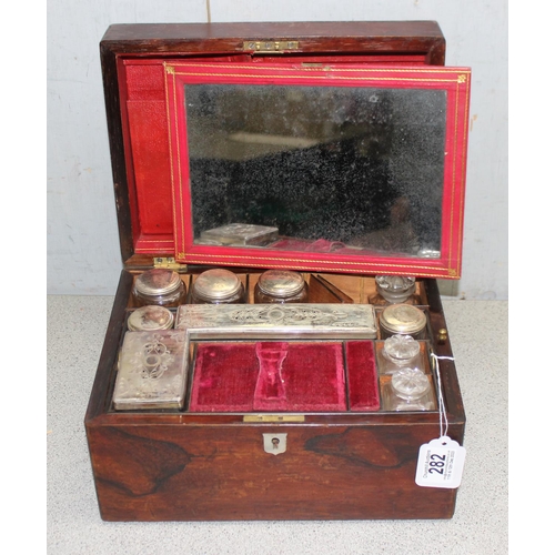 282 - Antique ladies travelling vanity case with silver plate and cut glass jars, red velvet interior appr... 