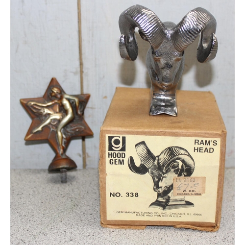 706 - Hood Gem Ram's head No. 338, seemingly unused in original box, and another in the form of a dancer o... 