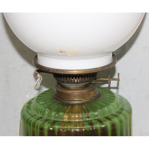 242 - Antique cast iron oil lamp with green glass reservoir, clear chimney and opaque bulbus shade approx.... 