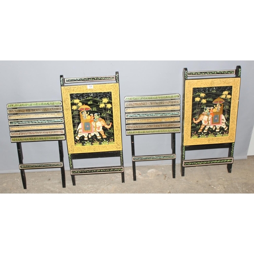 120 - A pair of 20th Century Indian painted folding occasional chairs, the backs depicting a couple seated... 