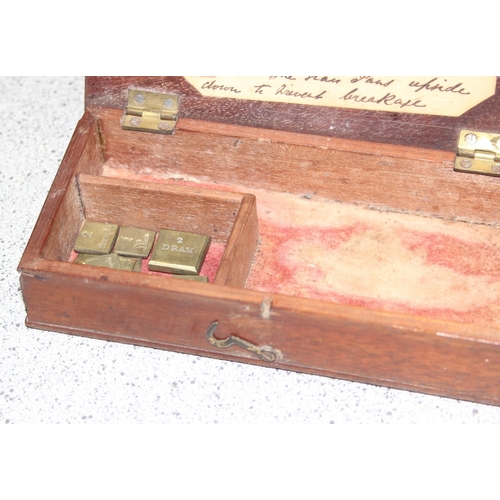 664 - Antique apothecary scales in box with some weights incl half scruple - 2 scruple and a half dram and... 