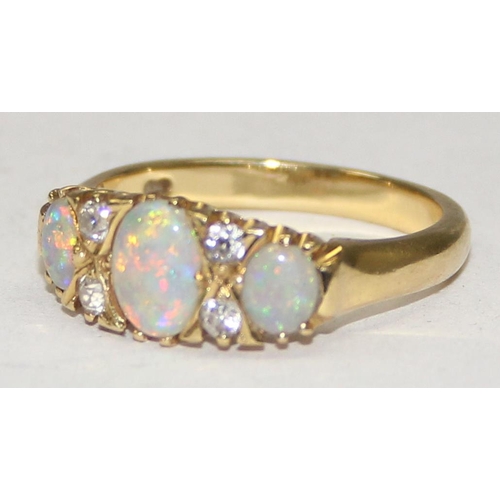 1108 - An 18ct gold trilogy opal and diamond ring, 3 opals are separated by 2 pairs of diamonds, marked and... 