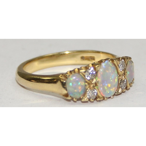 1108 - An 18ct gold trilogy opal and diamond ring, 3 opals are separated by 2 pairs of diamonds, marked and... 