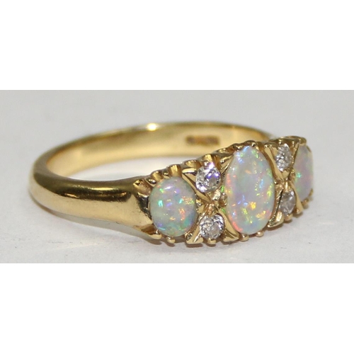 1108 - An 18ct gold trilogy opal and diamond ring, 3 opals are separated by 2 pairs of diamonds, marked and... 