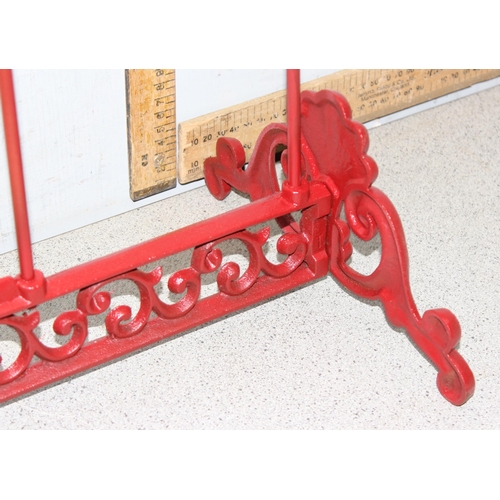 275 - A red painted cast iron Wellington boot rack, approx 56cm wide