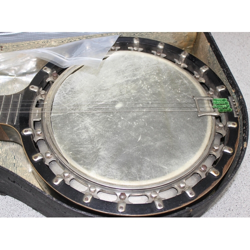 603 - An early 20th century 4 string banjolele in case, seemingly unmarked, with some contemporary sheet m... 