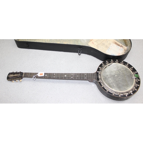 603 - An early 20th century 4 string banjolele in case, seemingly unmarked, with some contemporary sheet m... 