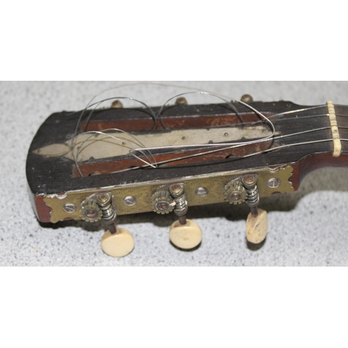 603 - An early 20th century 4 string banjolele in case, seemingly unmarked, with some contemporary sheet m... 