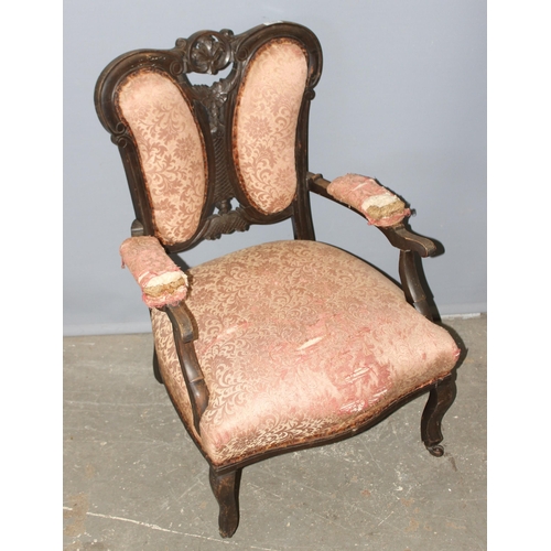 102 - Victorian mahogany low-seated arm chair with pierced decoration on ceramic castors