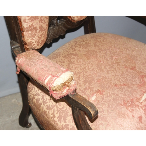 102 - Victorian mahogany low-seated arm chair with pierced decoration on ceramic castors