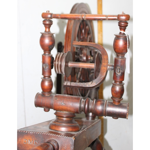 291 - An antique wooden spinning wheel, stamped DMD, approx 96cm tall