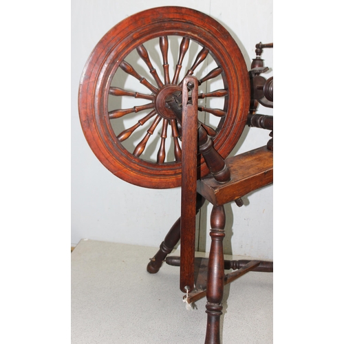 291 - An antique wooden spinning wheel, stamped DMD, approx 96cm tall