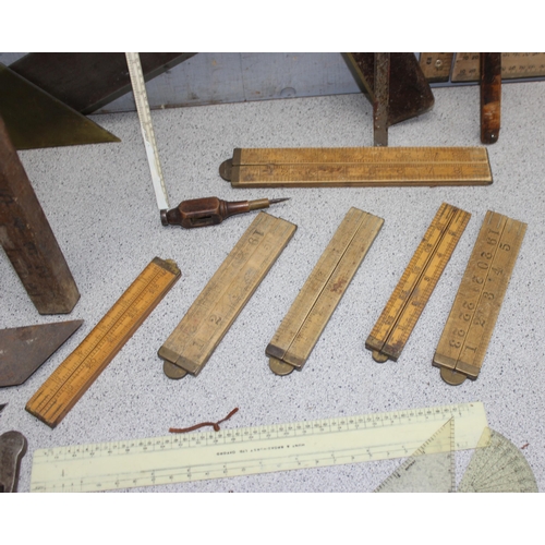 671 - Qty of vintage measuring equipment to include set squares, rulers and tape measures