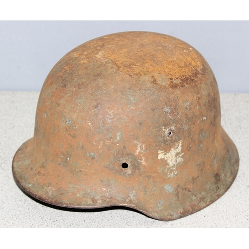 1470 - A WW2 period German helmet, believed to be an M35, no liner and remnants of decals, near relic condi... 