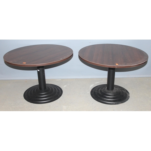 106 - A pair of low round tables with black painted metal bases, each approx 68cm in diameter x 46cm tall