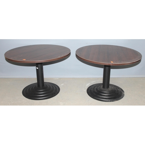 106 - A pair of low round tables with black painted metal bases, each approx 68cm in diameter x 46cm tall
