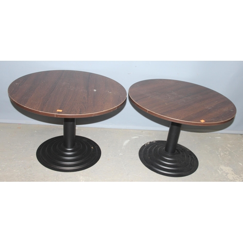 104 - A pair of low round tables with black painted metal bases, each approx 68cm in diameter x 46cm tall