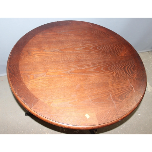 108 - A vintage wooden topped pub table with decorative wrought iron base, approx 91cm round x 74cm tall