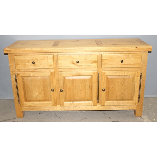 33 - A modern light oak sideboard with 3 drawers over 3 cupboards, likely Oak Furnitureland, approx 150cm... 