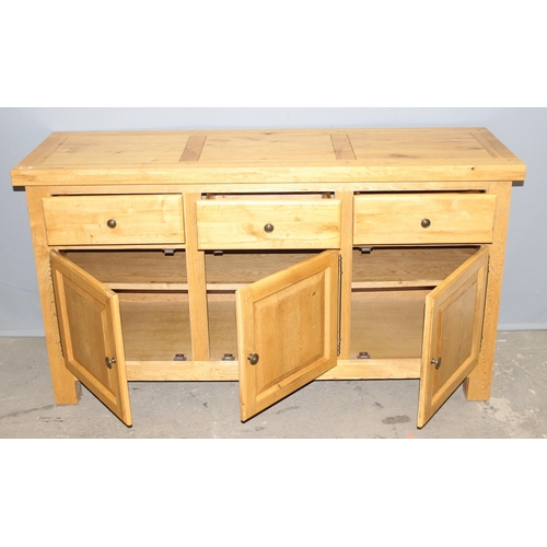 33 - A modern light oak sideboard with 3 drawers over 3 cupboards, likely Oak Furnitureland, approx 150cm... 