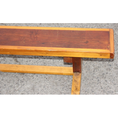 64 - A low stained pine bench, school gym style, approx 134cm wide x 60cm deep x 30cm tall