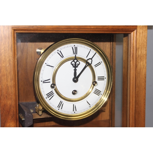 1320 - Light mahogany cased Vienna wall clock with brass finials, pendulum and key, approx 80cm