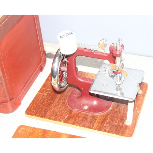 1502 - Vintage child's sewing machine in red leather carry case