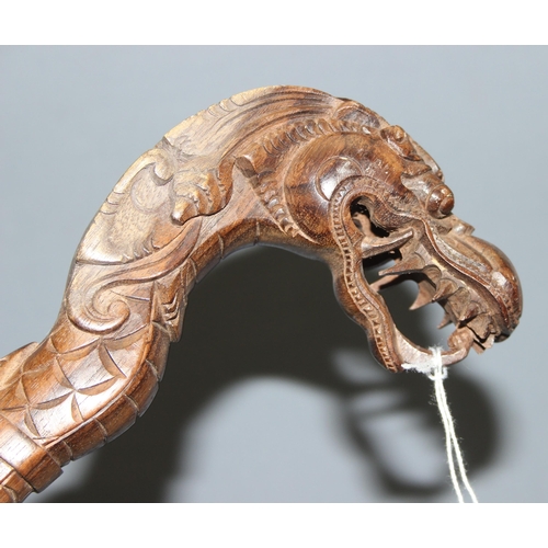 1611 - A Chinese carved hardwood walking stick formed a dragon, approx 98cm long