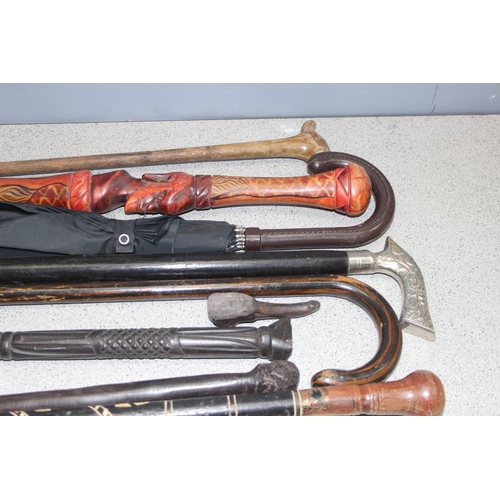 1708 - 9 x walking sticks, some with carved and painted details, and an umbrella (10)