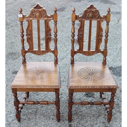 22 - A pair of Jacobean style light oak hall chairs with carved details