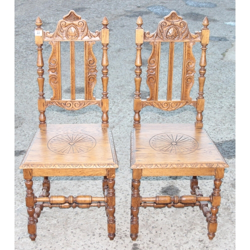 22 - A pair of Jacobean style light oak hall chairs with carved details