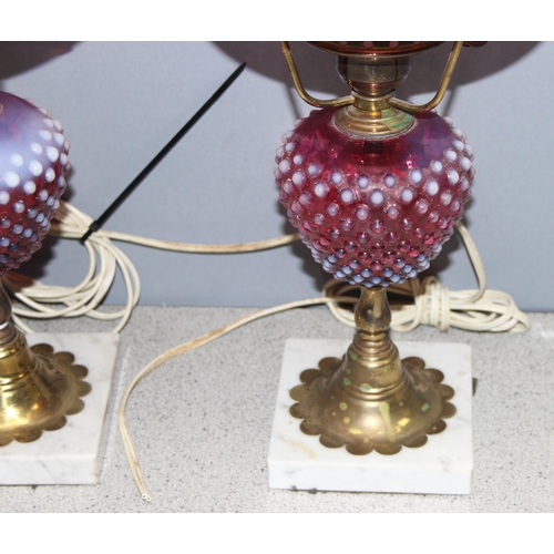 241 - Pair of Victorian cranberry hobnail opalescent glass and brass gas lamps mounted on white marble bas... 