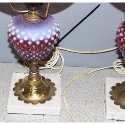 241 - Pair of Victorian cranberry hobnail opalescent glass and brass gas lamps mounted on white marble bas... 