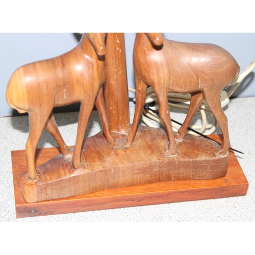 247 - Vintage African wooden table lamp with carved antelopes to base and cream shade, approx 60cm H