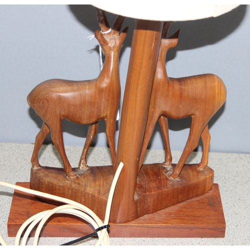 247 - Vintage African wooden table lamp with carved antelopes to base and cream shade, approx 60cm H