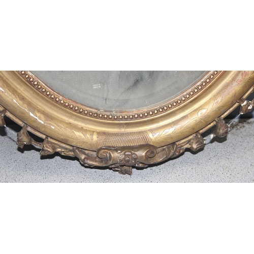 402 - A 19th century gilt framed oval mirror with carved wooden and gesso frame, approx 84cm x 52cm