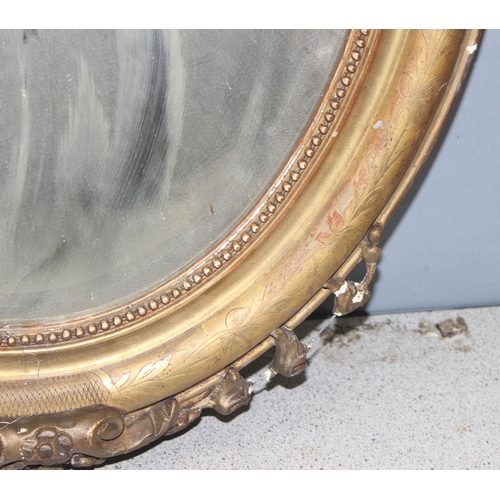 402 - A 19th century gilt framed oval mirror with carved wooden and gesso frame, approx 84cm x 52cm