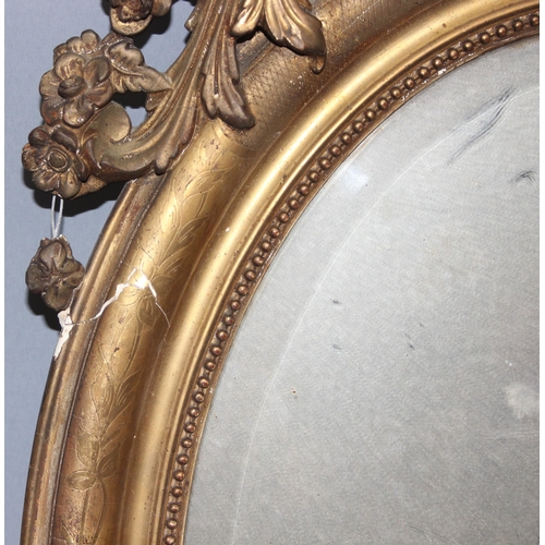 402 - A 19th century gilt framed oval mirror with carved wooden and gesso frame, approx 84cm x 52cm