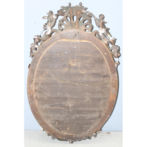 402 - A 19th century gilt framed oval mirror with carved wooden and gesso frame, approx 84cm x 52cm