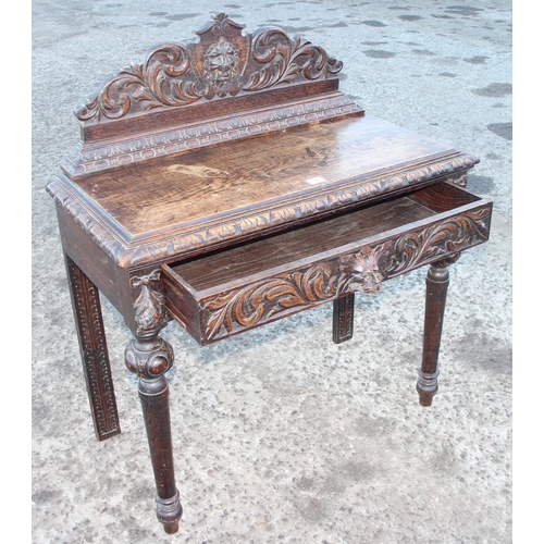 6 - A Jacobean Revival Green Man carved oak console or hall table, with singular sliding drawer carved w... 