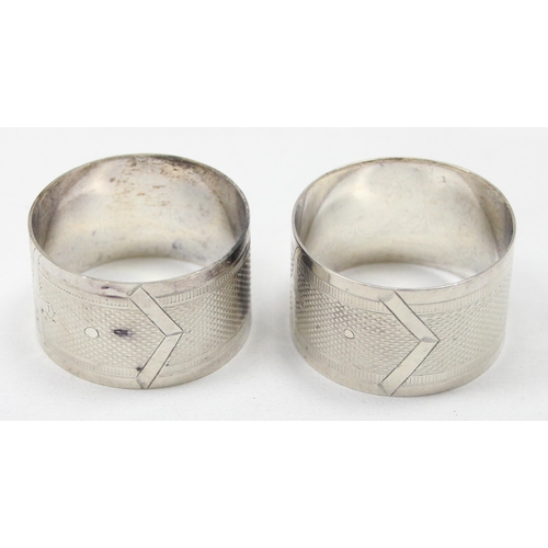 1024 - A pair of antique silver plated napkin rings in original leather case, each engraved with belt buckl... 