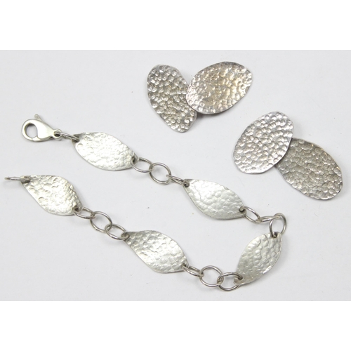 1158 - An Arts & Crafts style 925 silver bracelet of hammered form, the clasp marked and XRF tested and a p... 